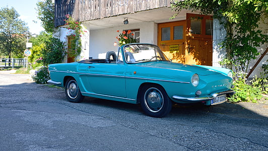 blue convertible parked near the white building thumbnail