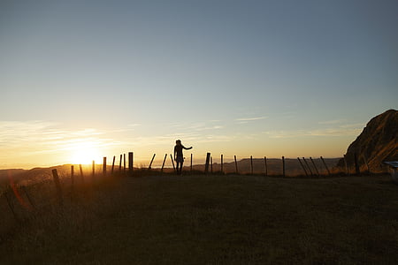 person standing near rail at golden hour thumbnail
