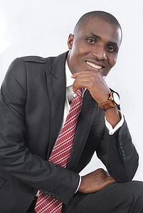 man in black suit posing and smiling thumbnail