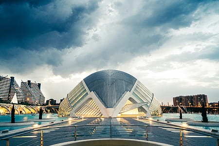 glass dome building surrounded with body of water and high rise buildings thumbnail