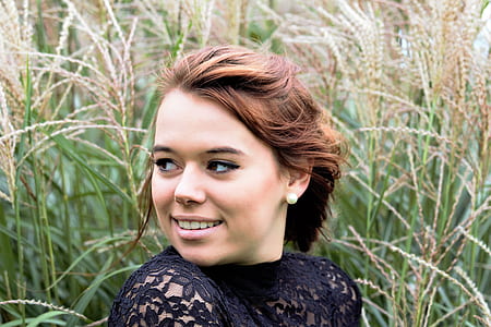 woman standing near tall grass outside during daytime thumbnail
