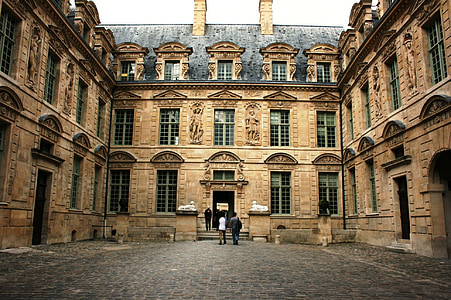 two person walking near brown building thumbnail
