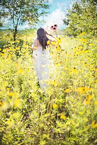 woman wearing white dress on bed of yellow flowers thumbnail