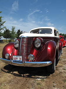 classic white and red car on grass field thumbnail