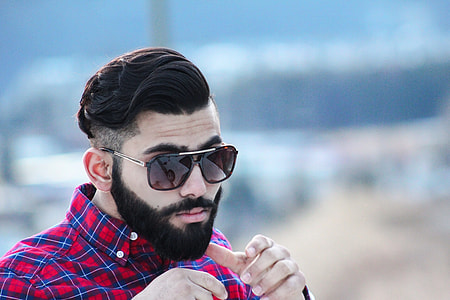 tilt shift lens photography of man wearing red and blue plaid button-up shirt thumbnail