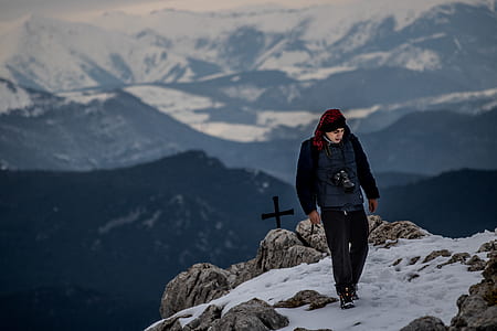 man walking on mountain top during daytime thumbnail