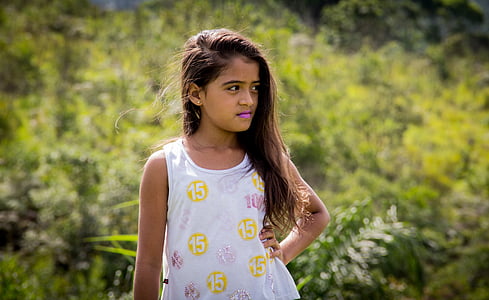 girl in white tank top standing beside plants thumbnail
