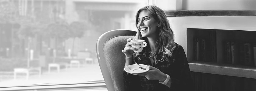 grayscale photo of woman holding saucer and teacup thumbnail