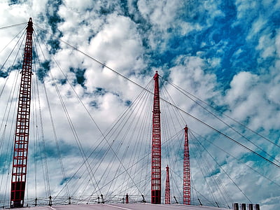 low-angle photography of red metal towers with wires during daytime thumbnail