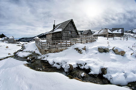 Black Wooden House Surrounded by Snow Under White Clouds thumbnail