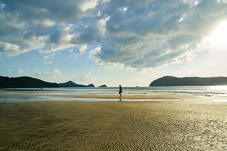 silhouette of man walking on seashore during daytime thumbnail