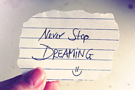 person holding crop paper with Never Stop Dreaming note thumbnail
