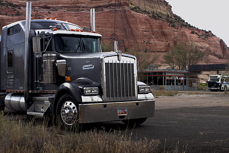 grey semi truck near brown mountain during daytime thumbnail