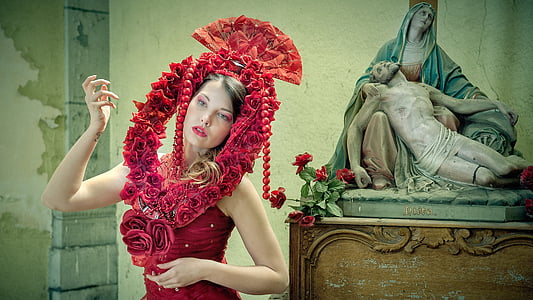 woman with red headdress beside religious image statue thumbnail