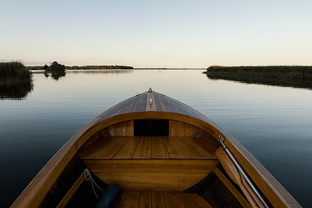 brown wooden boat facing body of water at daytime thumbnail