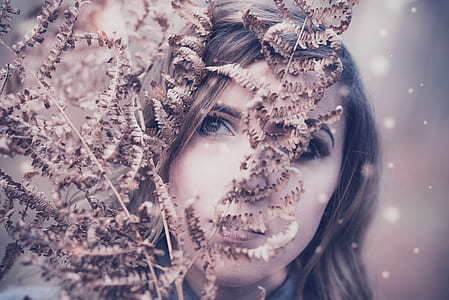 woman standing beside brown leaf plant thumbnail