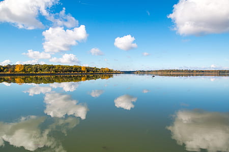 body of water with clouds and sky reflection thumbnail
