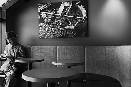 grayscale photography of man near table and painting thumbnail