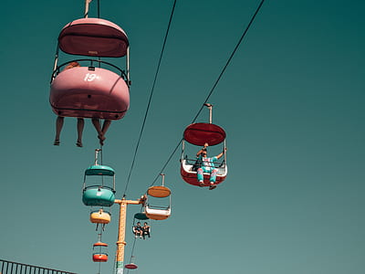 pink, blue, and yellow cable transportation with people at daytime thumbnail