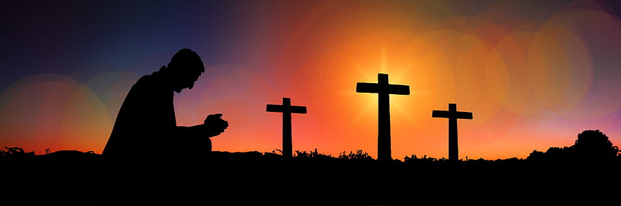 silhouette of man praying with three cross in background thumbnail
