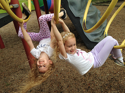 two girls hanging holding yellow bars thumbnail