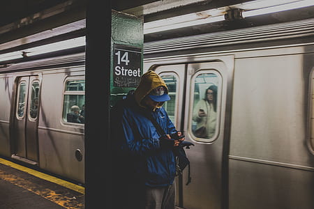 person wearing blue flat-brimmed cap and blue hoodie standing besides the pole thumbnail
