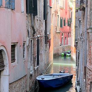 blue jon boat between buildings thumbnail