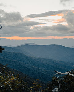 top view of green landscape mountain under white and grey skies thumbnail