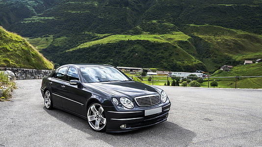 black Mercedes-Benz sedan parking on road near mountain at daytime thumbnail