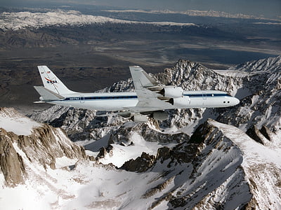 white airliner over mountains thumbnail
