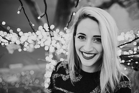 grayscale photo of woman near string lights thumbnail
