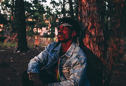 man crouching in front of tree thumbnail