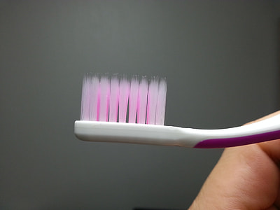 person holding pink and white toothbrush thumbnail