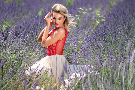 woman in red sleeveless top and white skirt sitting in lavender field thumbnail