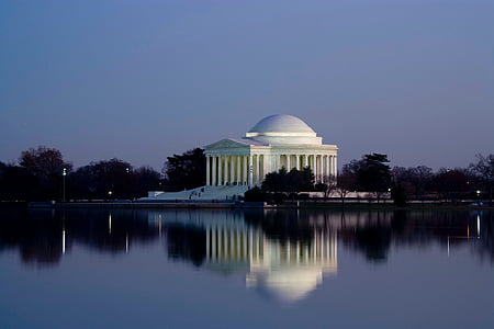 white concrete building by the body of water at night thumbnail