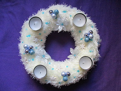 four white candles placed on white wreath thumbnail