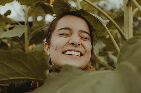 woman smiling surrounded with plants during daytime thumbnail