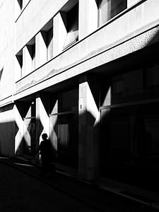 person standing beside concrete building thumbnail