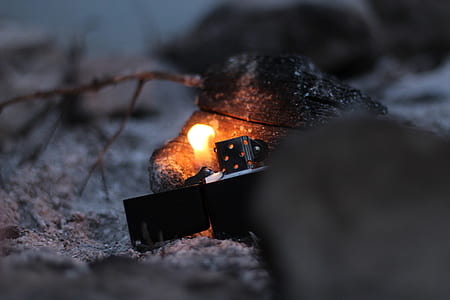 black flip-top lighter burning wood thumbnail
