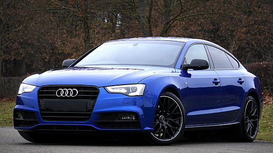 blue Audi A5 sedan near trees thumbnail