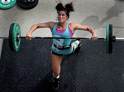 woman lifting barbell on black surface thumbnail