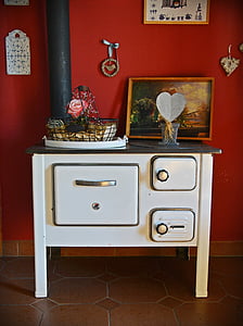 basket and painting on white and black cast iron stove thumbnail