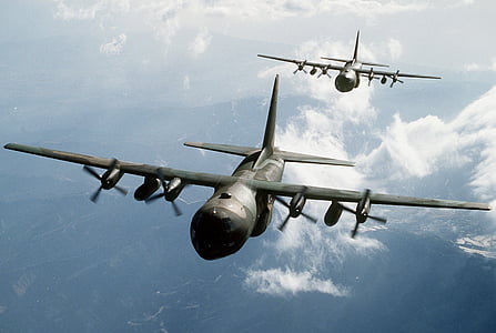 two green airplanes flying over clouds thumbnail
