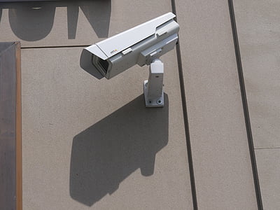 white surveillance camera hanging on wall at daytime thumbnail