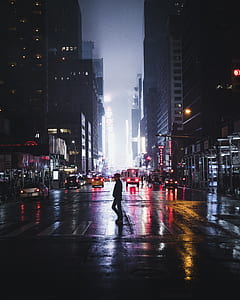 man walking on pedestrian line near high-rise buildings thumbnail