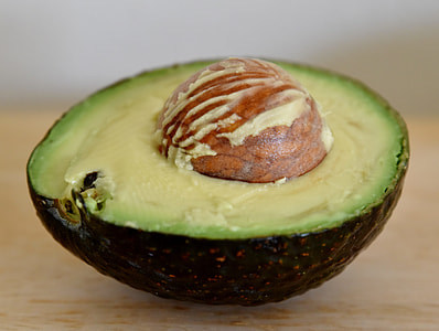 selective focus photography of sliced avocado on beige surface thumbnail