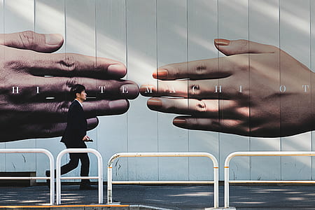 man walking on sidewalk with white metal rails thumbnail