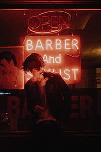 person standing near barber neon signage thumbnail