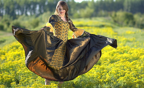 woman in black and yellow long-sleeved dress standing on green and yellow plant thumbnail