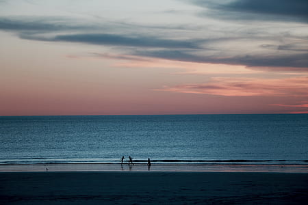 silhouette of three people by the beach thumbnail